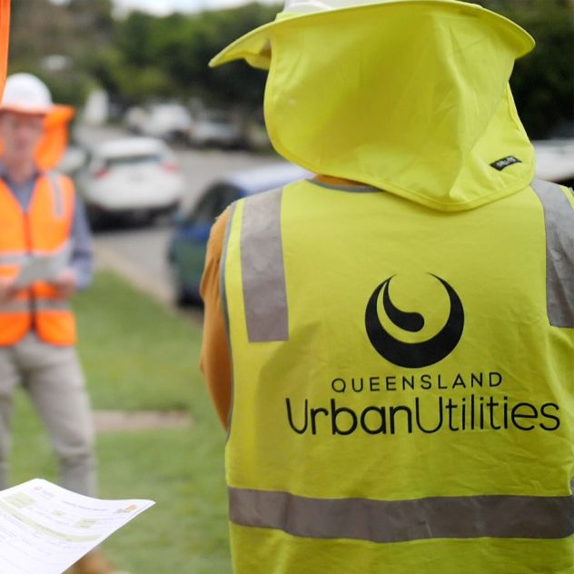 Person wearing an Urban Utilities hi-vis vest seen from behind, symbolising Diona's active involvement in water infrastructure projects.