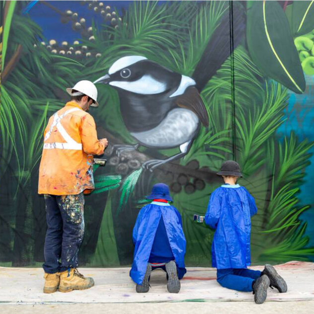 Primary school students painting a colourful mural on an odour control unit in Canberra.
