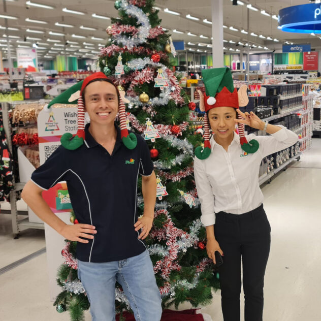 Two Diona staff standing in front of the Kmart Wishing Tree, symbolising community support and festive generosity
