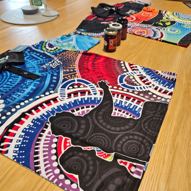 Indigenous Australian cuisine from Figjam & Co and NAIDOC Week polo shirts displayed as prizes.