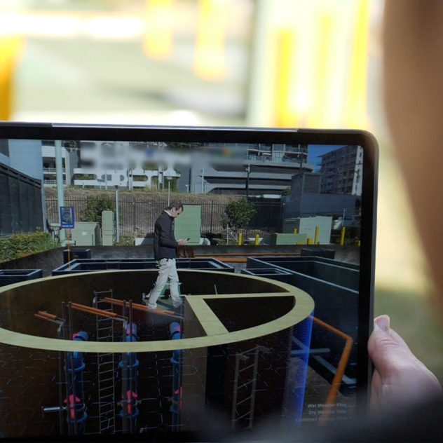 Close-up view of an iPad displaying the augmented reality app for the Grey Street Pump Station project.