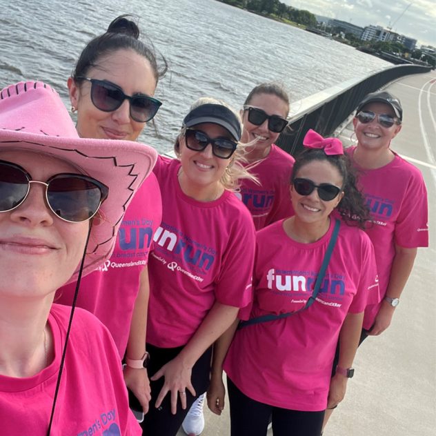 Team Diona Gals and Pals wearing bright pink t-shirts by the Brisbane River for the International Women's Day Fun Run.
